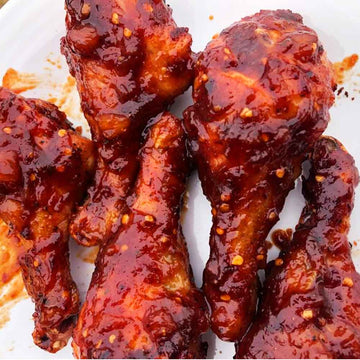 saucy cooked atomic pineapple wings on a white plate