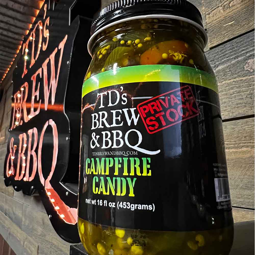 Jar of TD's Brew & BBQ Campfire Candy with neon sign in the background