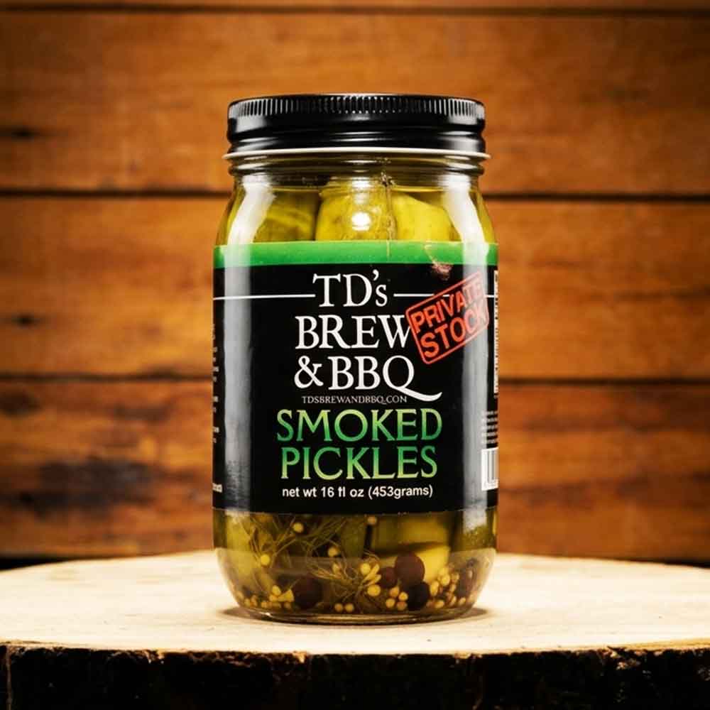 Jar of TD's Brew & BBQ Smoked Pickles on a wooden surface with a wooden background